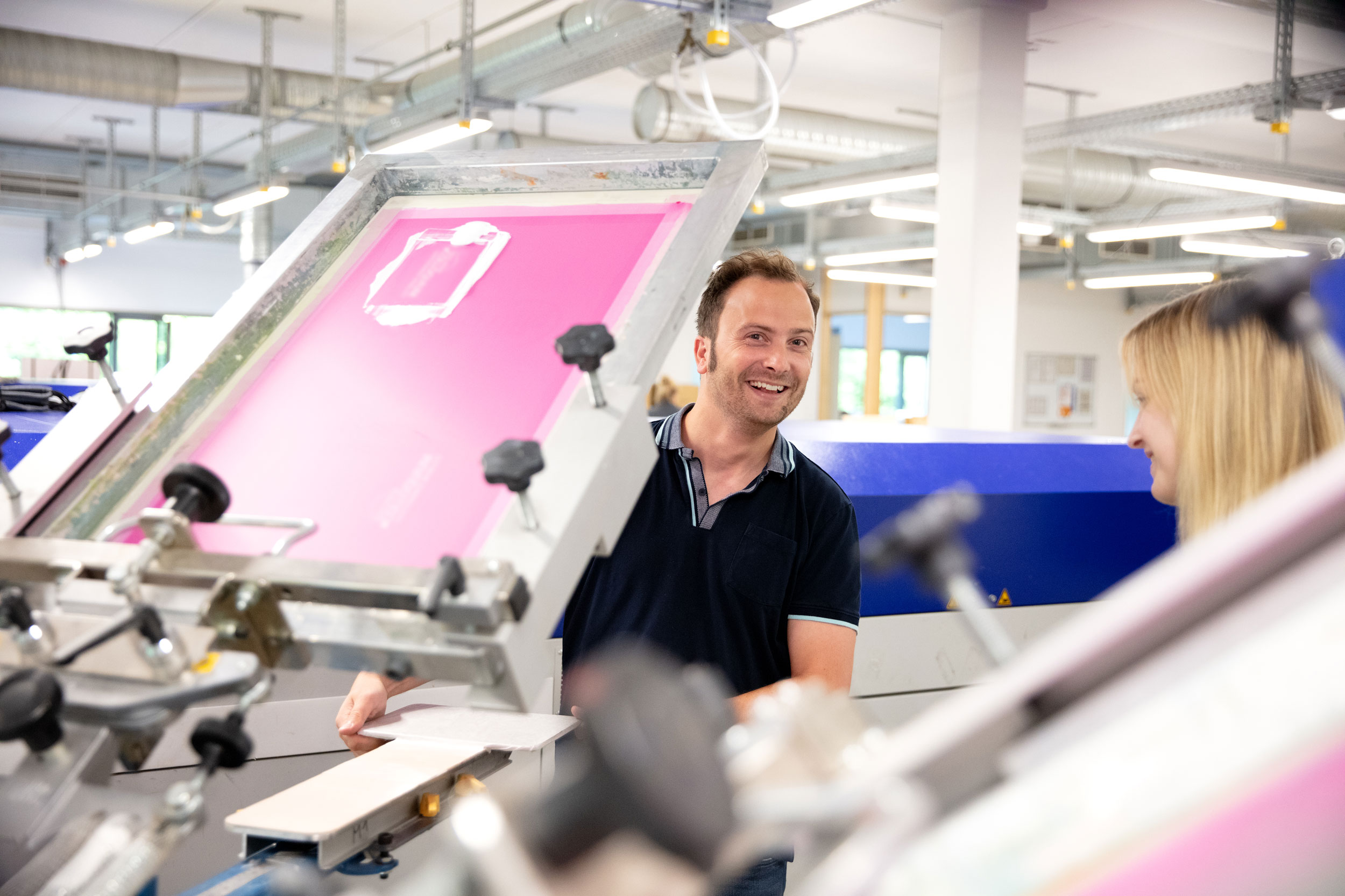 prosigno Mitarbeitende an Siebdruckmaschine