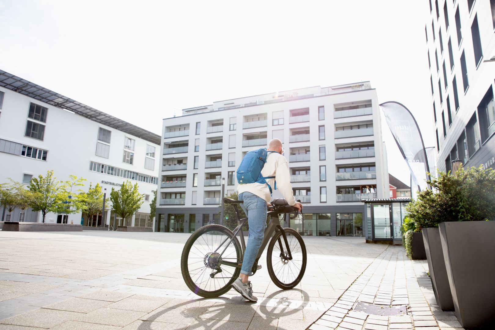 Halfar Mitarbeitender fährt mit Jobrad über einen Platz