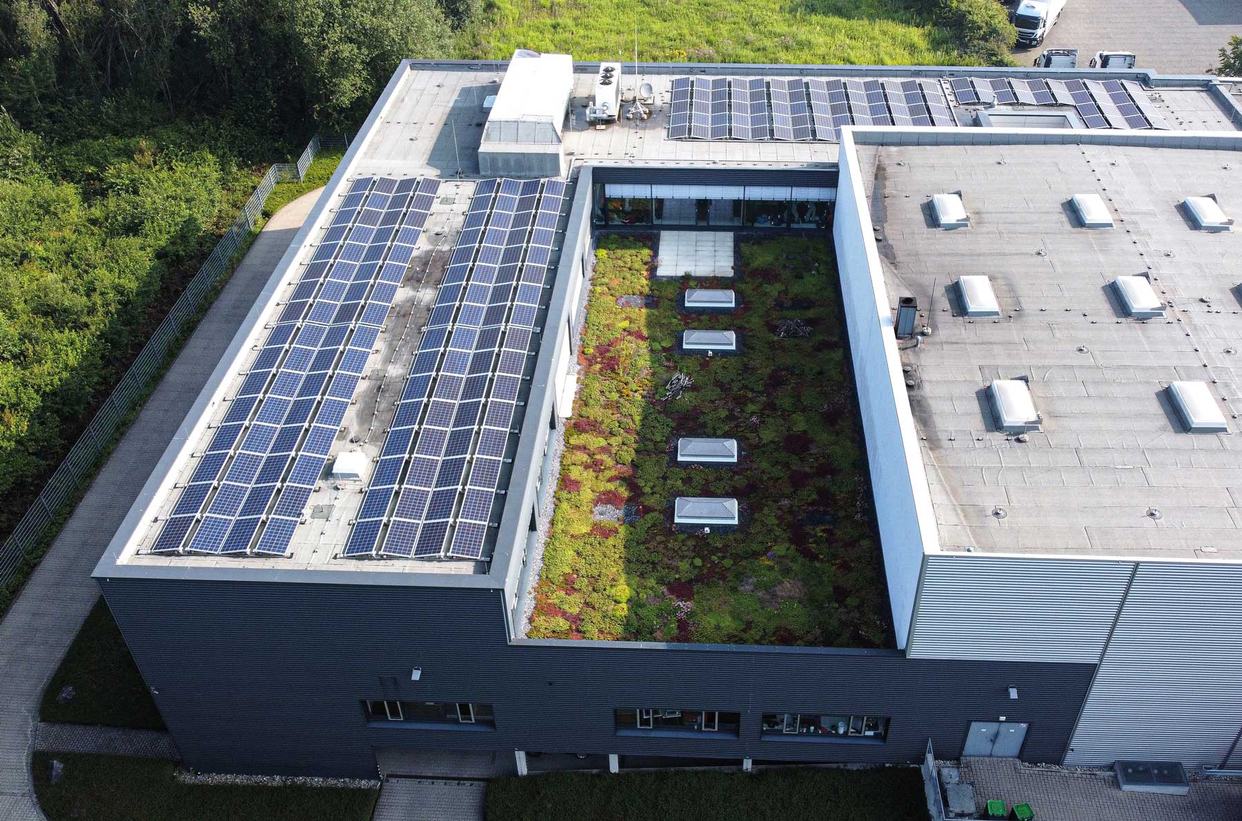 Firmengebäude mit Solaranlage und Grünfläche auf dem Dach