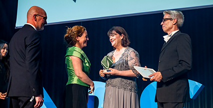 Preisverleihung mit Übergabe eines Awards auf Bühne bei der PSI Academy