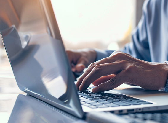 Hand auf Tastatur eines Laptops