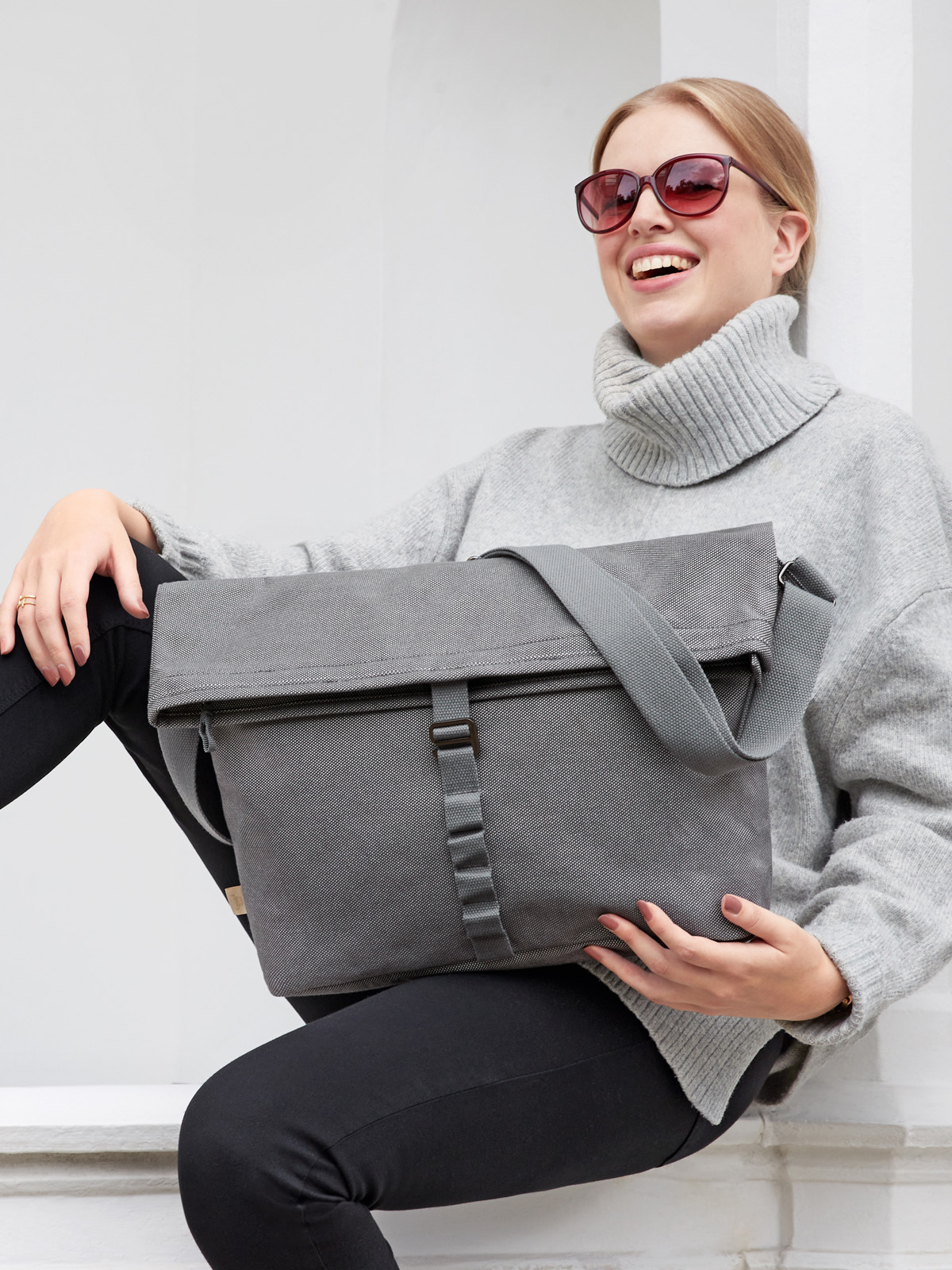 Umhaengetasche LOOM grau auf dem Schoss