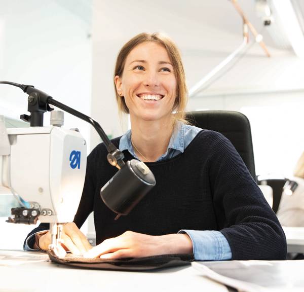 Eine Mitarbeiterin des HALFAR® Repair Services repariert eine Tasche