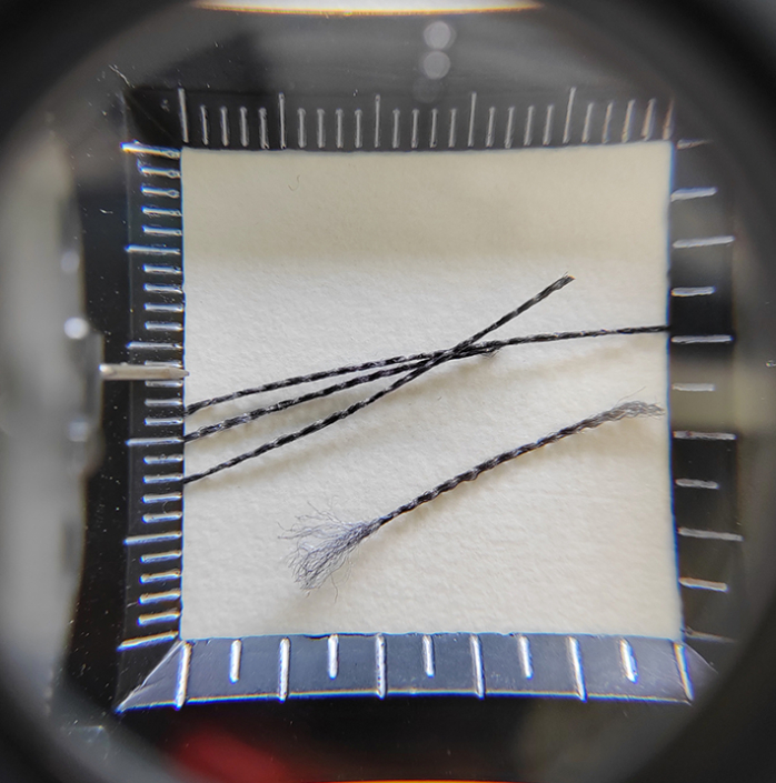 Polyesterfilamente im Messraster zur Analyse von Faseraufbau und Materialstärke