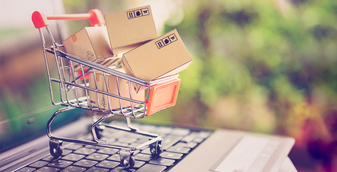 Einkaufswagen mit Paketen auf Laptop