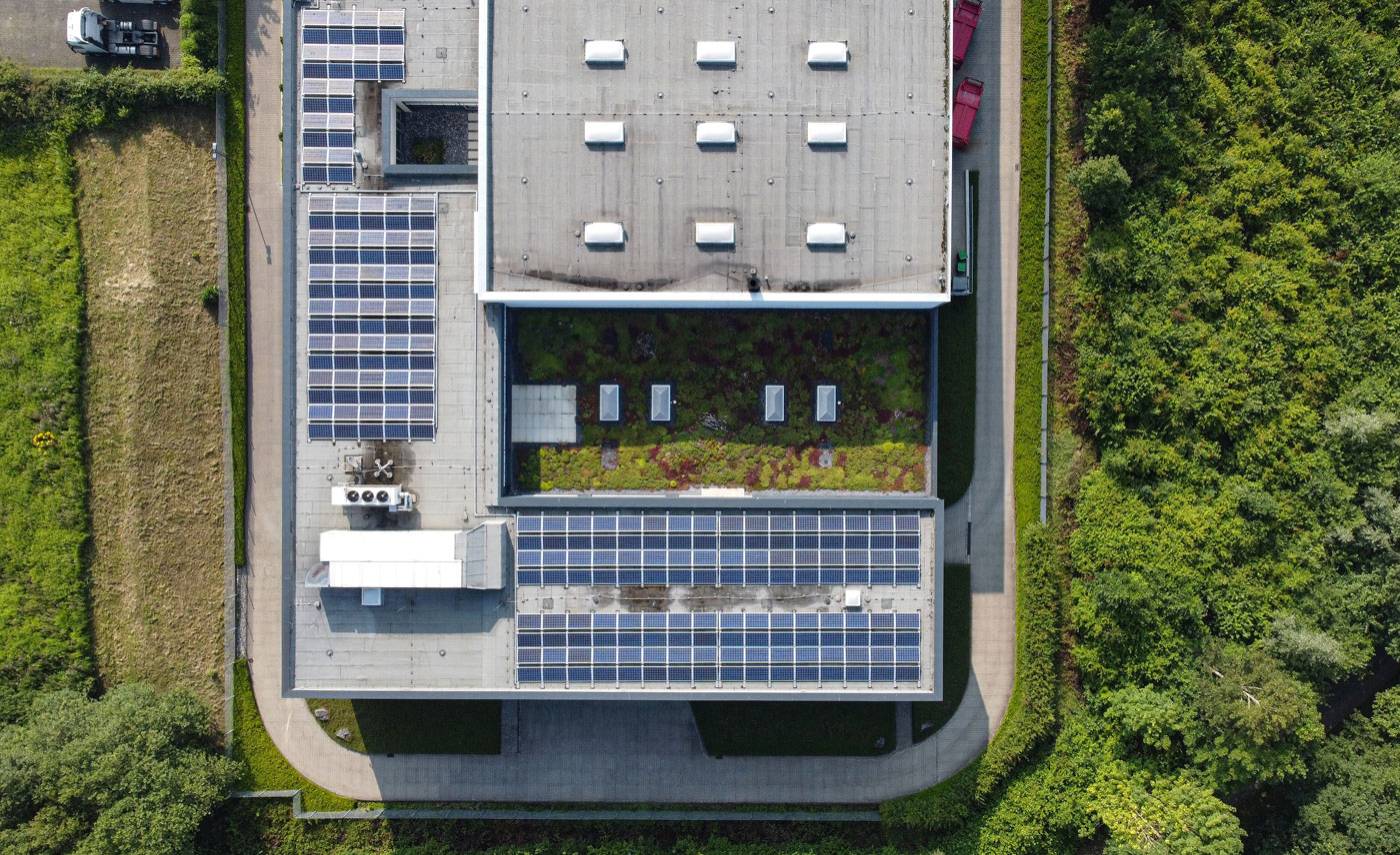 Firmengebäude mit Solaranlage und Grünfläche auf dem Dach