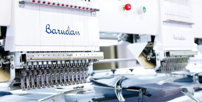 Stickmaschine verarbeitet Material fuer individuelle Veredelungen bei Halfar.